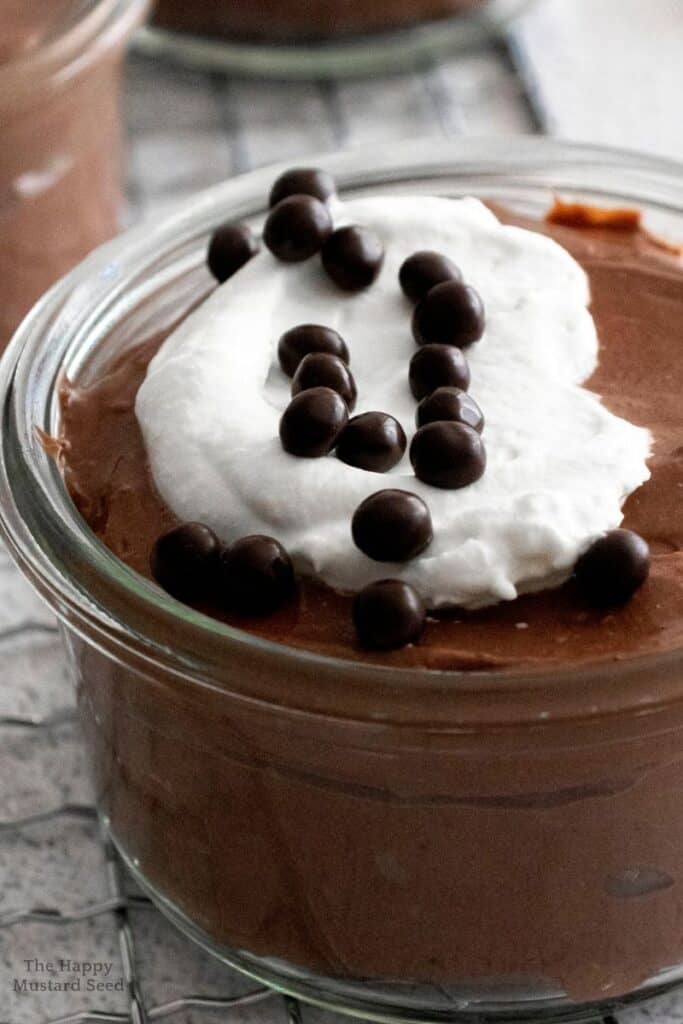 close image of chocolate cheesecake mousse in jar with whipped cream
