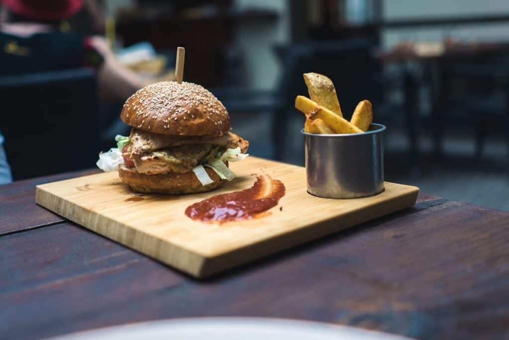 Burger and chips with sauce on a wooden tray