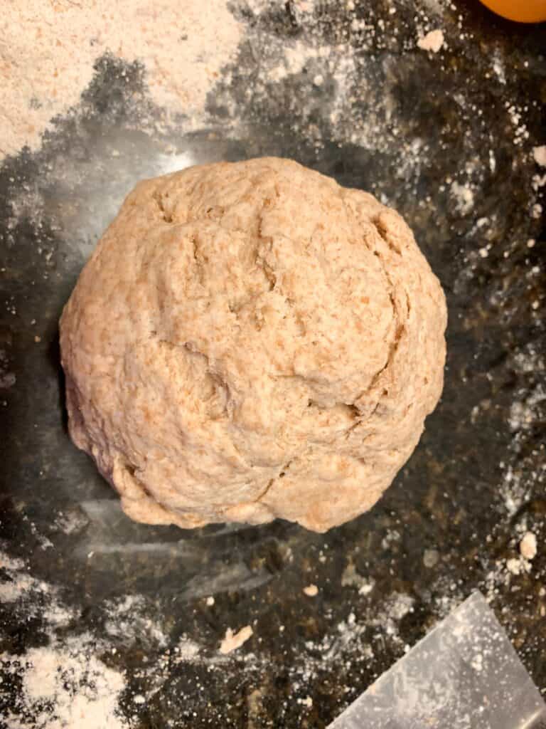 homemade sourdough whole wheat tortilla dough formed in a ball.