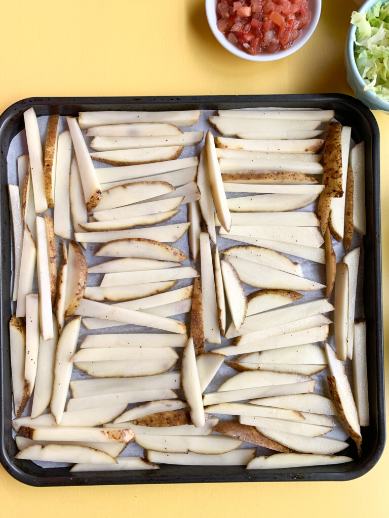 sliced potatoes on baking sheet for carne asada fries