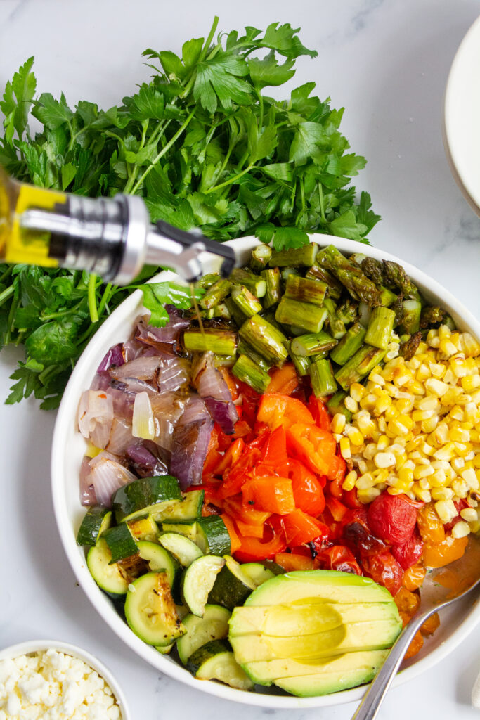 grilled vegetable salad with olive oil being drizzled on top