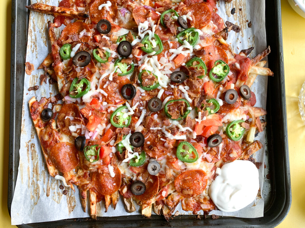 pizza fries recipe on top of baking sheet with olives and jalapeños