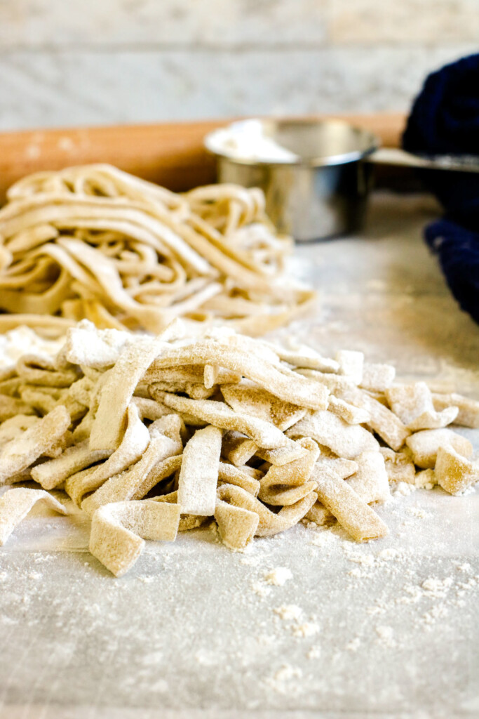 front view of homemade pasta without machine on floured surface