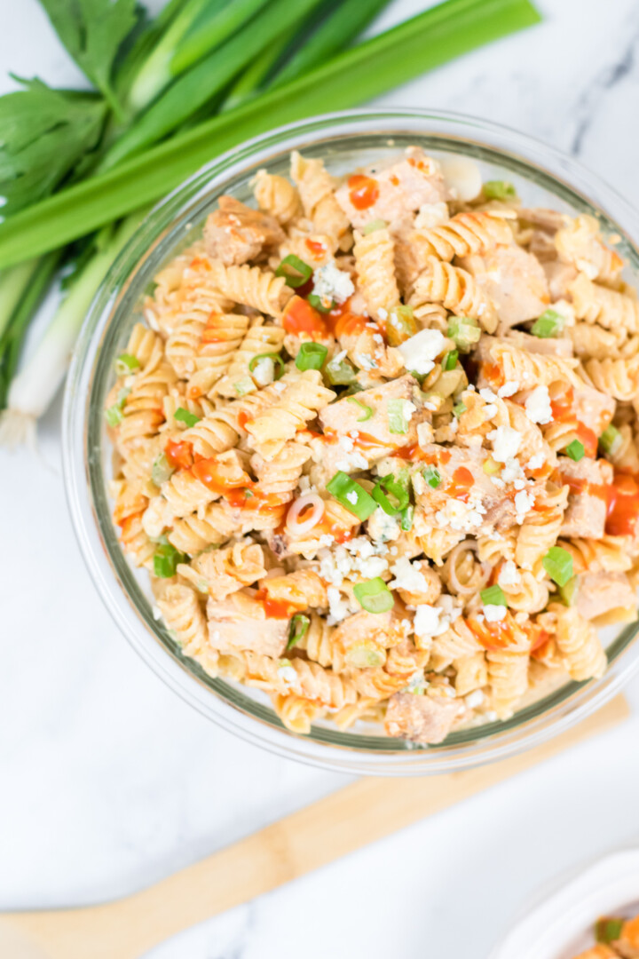 one bowl of buffalo chicken pasta salad with green onions